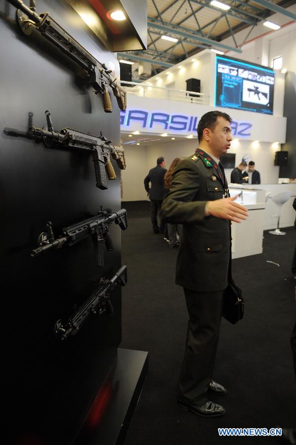 A military officer visits a Turkish firearms company booth in Istanbul, Turkey, May 7, 2013. The 11th International Defence Industry Fair was opened on Tuesday, with 781 companies from 82 countries and regions attending the four-day fair. (Xinhua/Lu Zhe)