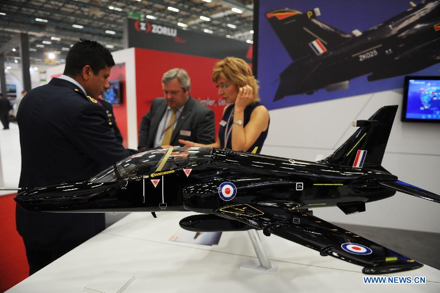 Guests talk with each other in front of the booth of an aircraft company from France in Istanbul, Turkey, May 7, 2013. The 11th International Defence Industry Fair was opened on Tuesday, with 781 companies from 82 countries and regions attending the four-day fair. (Xinhua/Lu Zhe)