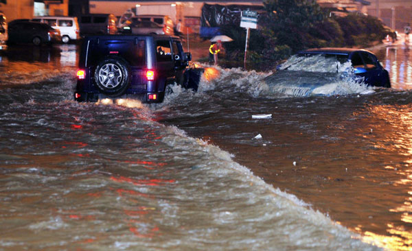 Cars rush through the waterlogging in Changsha, capital of Central China's Hunan province on May 7, 2013. [Photo/Xinhua]