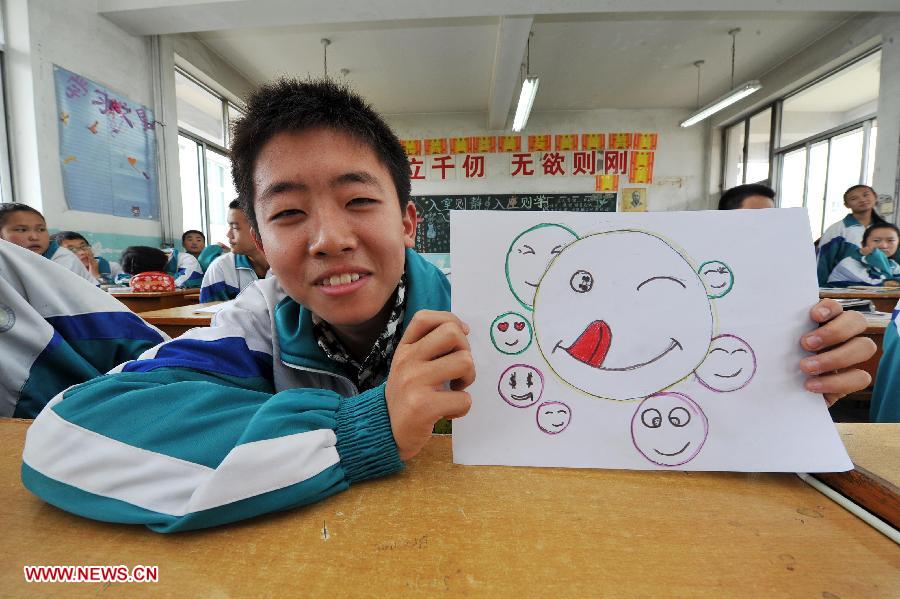 A student shows his painting of smiling faces to celebrate the World Smile Day at the No. 20 Middle School in Yinchuan, capital of northwest China's Ningxia Hui Autonomous Region, May 8, 2013. (Xinhua/Peng Zhaozhi) 
