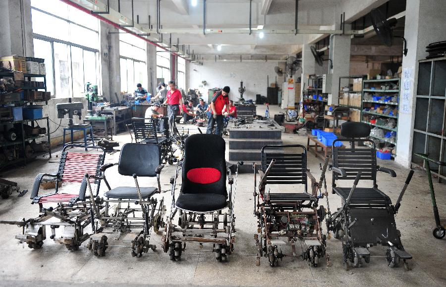 Completed wheelchairs are seen in a workshop in Guangzhou, capital of south China's Guangdong Province, May 6, 2013. Liu Tie'er, a 71-year-old local resident, invented a wheelchair capable of climbing stairs in an effort to help his disabled wife and many more who are in need. (Xinhua/Lu Hanxin) 