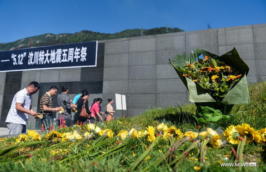 People mourn for victims who died in a massive earthquake five years ago in Yingxiu Township of Wenchuan County, southwest China's Sichuan Province, May 12, 2013. The devastating 8.0-magnitude earthquake on May 12, 2008 left more than 80,000 people dead or missing. (Xinhua/Bai Yu)