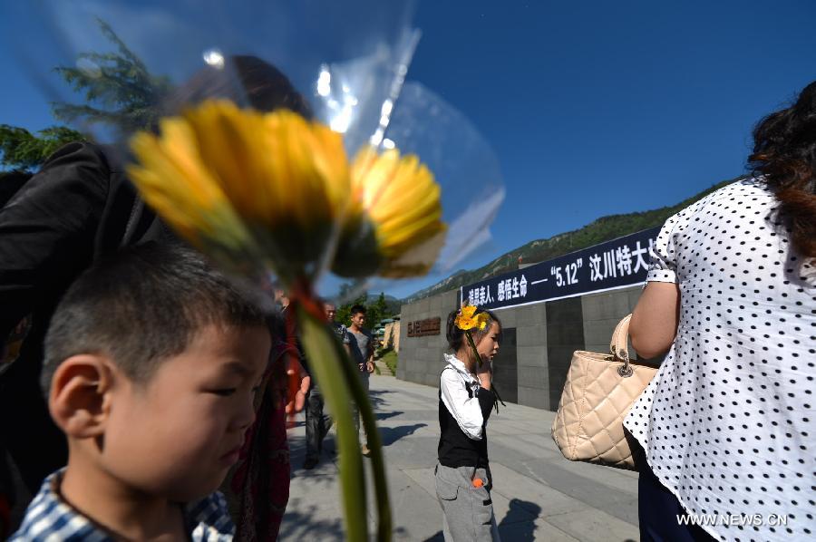 Children holding flowers in hand mourn for victims who died in a massive earthquake five years ago in Yingxiu Township of Wenchuan County, southwest China's Sichuan Province, May 12, 2013. The devastating 8.0-magnitude earthquake on May 12, 2008 left more than 80,000 people dead or missing. (Xinhua/Bai Yu)