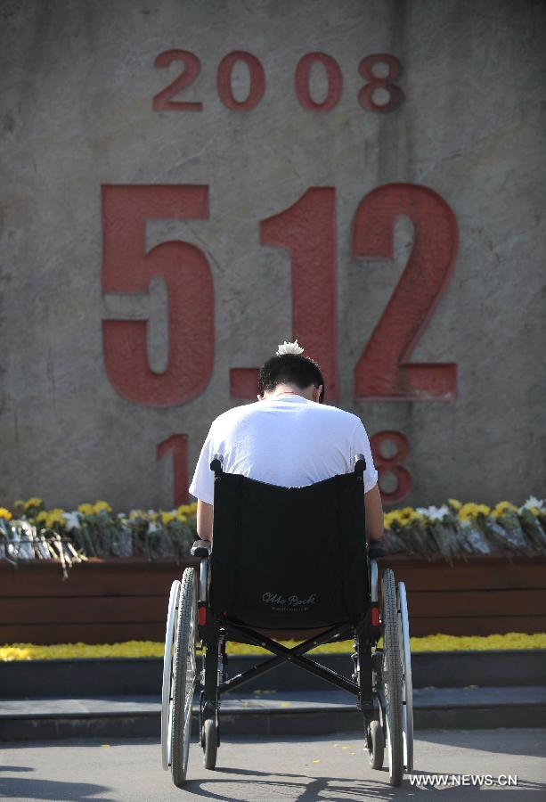 A young man who lost his legs in the earthquake five years ago mourns for victims of the quake in front of a monument in Beichuan, southwest China's Sichuan Province, May 12, 2013. Mourners gathered on Sunday in Beichuan, one of the worst hit regions in the Wenchuan Earthquake, to mark the fifth anniversary of the deadly earthquake on May 12, 2008 in which more than 80,000 people were killed or missing. (Xinhua/Xue Yubin) 