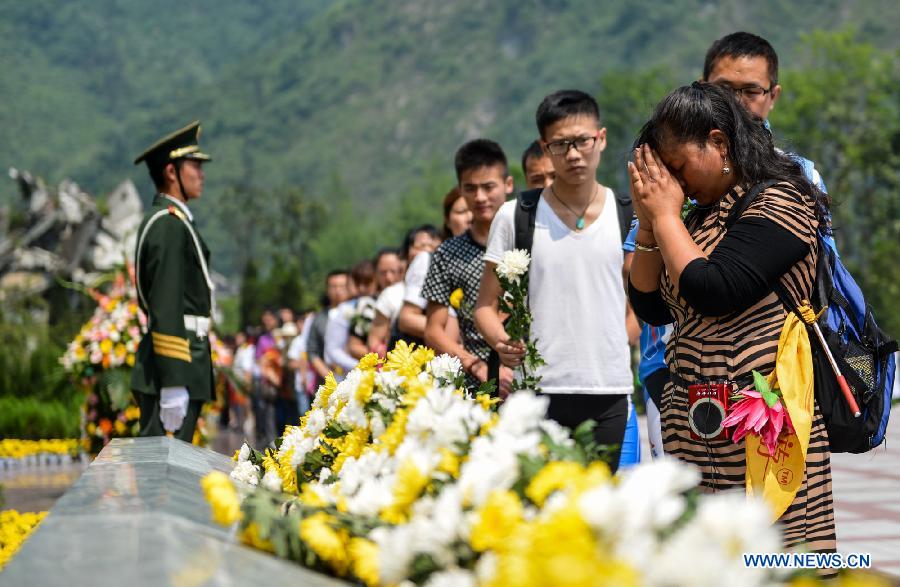 eople mourn for victims who died in a massive earthquake five years ago, at the remains of Xuankou Middle School in Yingxiu Town, southwest China's Sichuan Province, May 12, 2013. A memorial event was held here on Sunday to mark the fifth anniversary of the deadly earthquake which havoced Sichuan on May 12, 2008. (Xinhua/Bai Yu) 