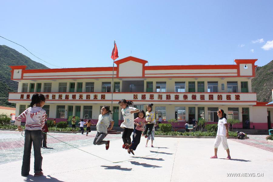 Photo taken on July 19, 2010 shows pupils playing on the playground in a newly-built school in Xinchengzi Township of Longnan City, northwest China's Gansu Province. In the year of 2008, a massive earthquake occurred in Gansu's neighbouring province Sichuan, and Longnan was also battered by the disaster. During the past five years, a total of 3,905 reconstruction projects have been carried out in the city, where over 240,000 households have their houses rebuilt, and hundreds of schools and hospitals have been set up as well. (Xinhua/Wang Yaodong)