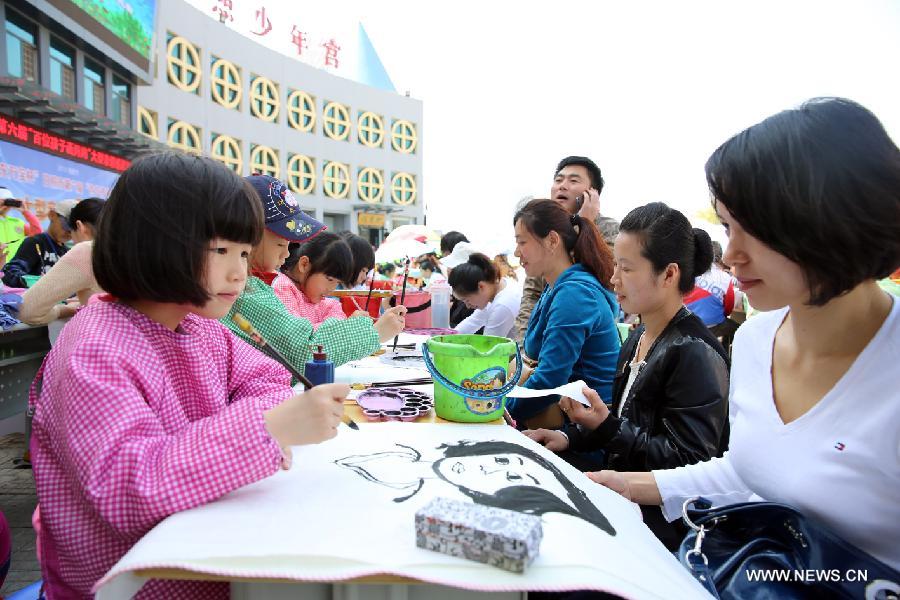 Children draw pictures of their mother during a celebration of the Mother's Day in Rizhao, east China's Shandong Province, May 12, 2013. (Xinhua/Hui Xueye) 