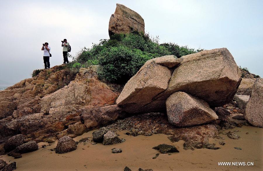 Two visitors take pictures at the Ping Chau Island in south China's Hong Kong, May 12, 2013. Ping Chau, also named Tung Ping Chau, lies in the northeast corner of Hong Kong and is part of the Hong Kong Geopark. The island is home to shale rocks in various shapes which makes it a popular tourist attraction. (Xinhua/Chen Xiaowei) 