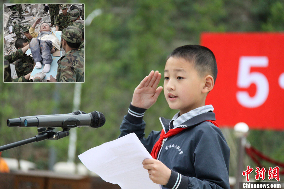 Lang Zheng expresses his gratitude at a flag-raising ceremony of the opening of Wenchuan Earthquake Memorial Museum, southwest China’s Sichuan province, May 9, 2013. When Lang Zheng was buried under a collapsed building he was only three year old. Lying on a plank used as stretcher, he rose up a thin arm to salute to eight PLA soldiers who pulled him out of debris, which was one of the most touching moments during the whole Wenchuan quake rescue. Now, Lang is in second grade in a primary school in Sichuan.  (Chinanews.com/Yang Chao) 