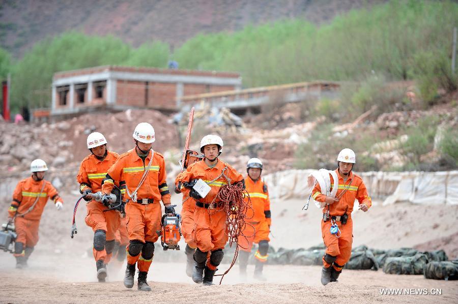 Fire fighters take part in a rescue mission during an earthquake drill in Qamdo, southwest China's Tibet Autonomous Region, May 13, 2013. The drill was held by local fire fighting department to test and evaluate their response and rescue ability in the event of disasters. (Xinhua/Wen Tao)  