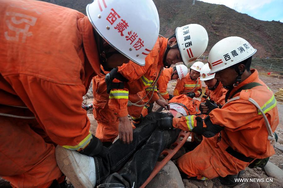 Fire fighters carry "an injured person" on a stretcher during an earthquake drill in Qamdo, southwest China's Tibet Autonomous Region, May 13, 2013. The drill was held by local fire fighting department to test and evaluate their response and rescue ability in the event of disasters. (Xinhua/Wen Tao) 