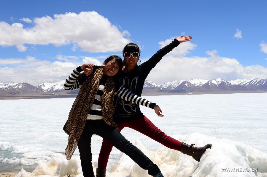 Girls of Tibetan ethnic group pose for a photo next to the icy lake Nam Co located at the boundary of Damxung and Baingoin counties, southwest China's Tibet Autonomous Region, on May 12, 2013. Lake Nam Co, the highest saltwater lake of the world at 4,718 meters above the sea level, is regarded as a sacred lake in Tibetan Buddhism. (Xinhua/Chen Tianhu)  