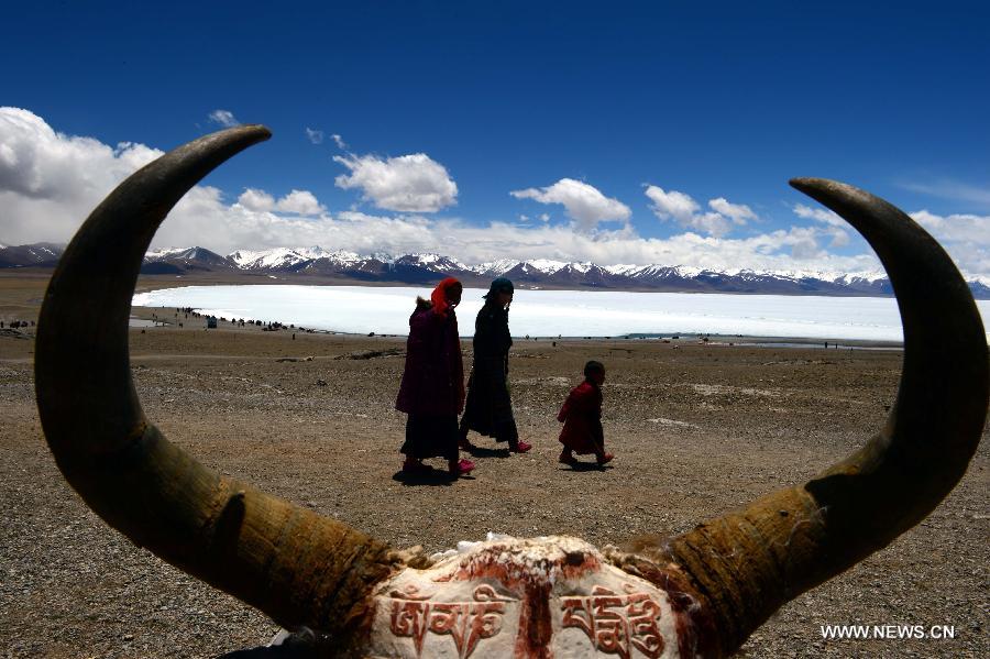 People walk along the icy lake Nam Co located at the boundary of Damxung and Baingoin counties, southwest China's Tibet Autonomous Region, on May 12, 2013. Lake Nam Co, the highest saltwater lake of the world at 4,718 meters above the sea level, is regarded as a sacred lake in Tibetan Buddhism. (Xinhua/Chen Tianhu)  