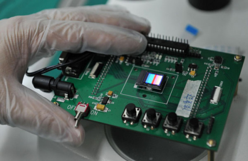 Ji Huaxia checks an OLED micro display on an integrated circuit plate, May 9, 2013. [Photo/Xinhua]