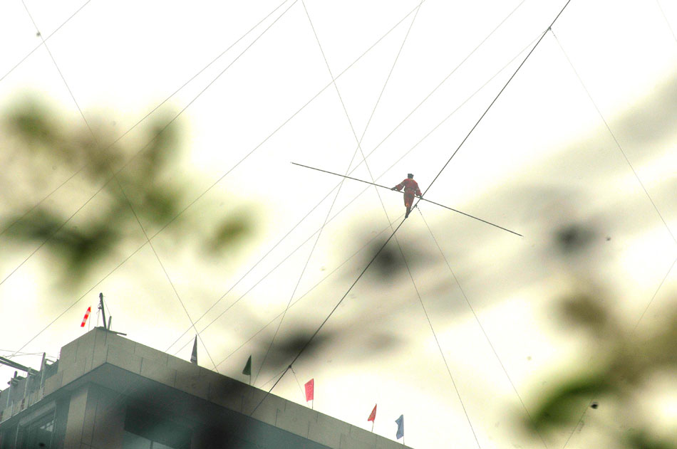 Tightrope walker Adili Wuxor walks on crossed steel wires that are 106 meters above the ground near Desheng River in Hangzhou, east China's Zhejiang province, May 5, 2013. (Xinhua/Zhu Yinwei)