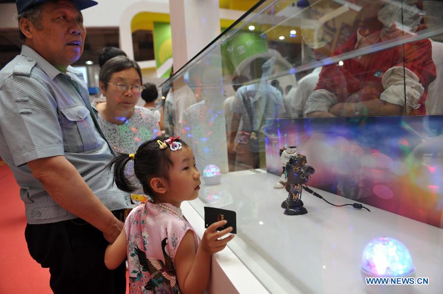 Visitors look at an item displayed at the 2013 Taiwan Trade Fair in Shijiazhuang, capital of north China's Hebei Province, May 16, 2013. The four-day fair attracting more than 180 enterprises from southeast China's Taiwan kicked off here on Thursday. (Xinhua/Zhu Xudong)