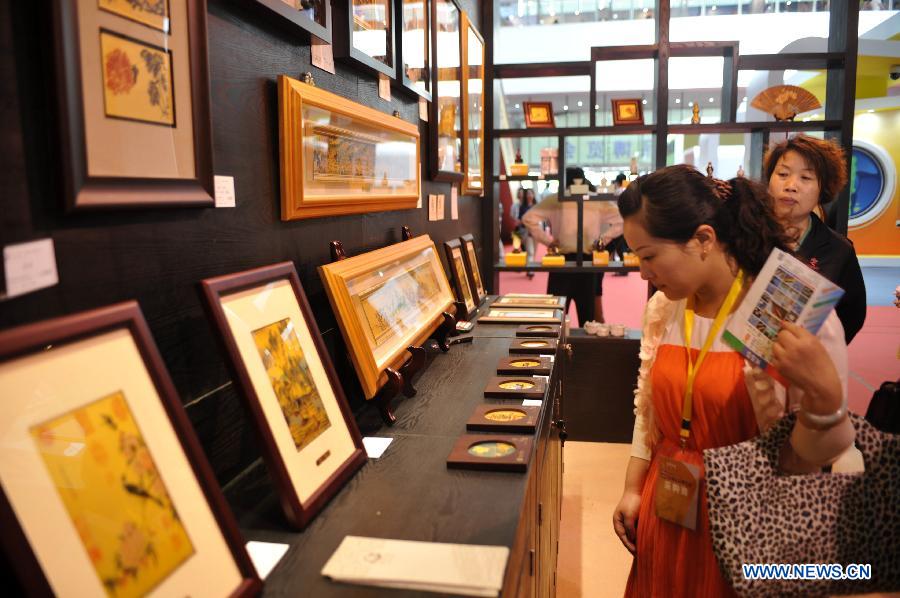 People look at items displayed at the 2013 Taiwan Trade Fair in Shijiazhuang, capital of north China's Hebei Province, May 16, 2013. The four-day fair attracting more than 180 enterprises from southeast China's Taiwan kicked off here on Thursday. (Xinhua/Zhu Xudong)