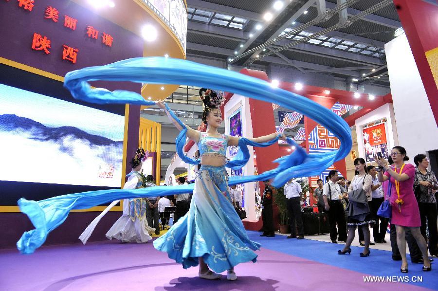 A dancer from northwest China's Shanxi Province dances at the province's pavilion on the 9th China International Cultural Industries Fair (ICIF) in Shenzhen, south China's Guangdong Province, May 17, 2013. The four-day ICIF kicked off on Friday here, attracting over two thousand exhibitors. (Xinhua/Liang Xu) 