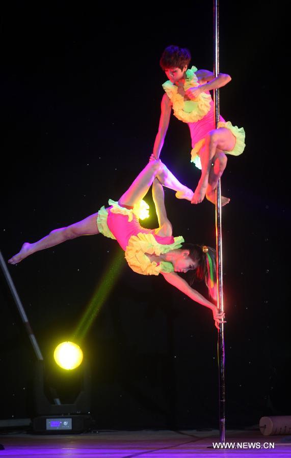 Dancers of China's National Pole Dancing Team perform in "Fairies on the Pole," the world's first pole dance drama, in Tianjin, north China, May 17, 2013. (Xinhua/Liu Dongyue)