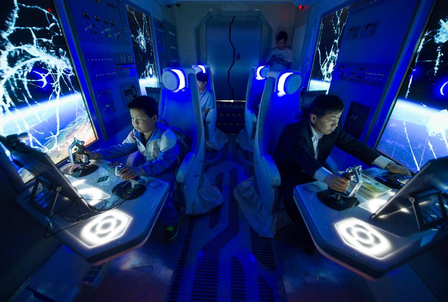 Visitors experience a simulative space journey in a capsule during a science exhibition in Beijing, capital of China, May 19, 2013. The exhibition is a part of the National Science and Technology Week and will last till May 25. (Xinhua/Luo Xiaoguang) 