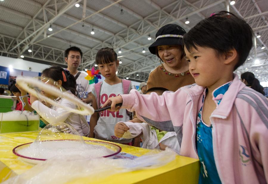 Children experience science experiments during a science exhibition in Beijing, capital of China, May 19, 2013. The exhibition is a part of the National Science and Technology Week and will last till May 25. (Xinhua/Luo Xiaoguang) 