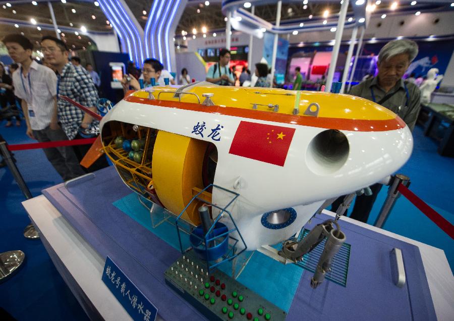 Visitors look at a model of the manned submersible "Jiaolong" during a science exhibition in Beijing, capital of China, May 19, 2013. The exhibition is a part of the National Science and Technology Week and will last till May 25. (Xinhua/Luo Xiaoguang) 