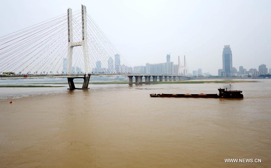 A cargo ship sails near the Nanchang Bridge on the Ganjiang River in Nanchang, capital of east China's Jiangxi Province, May 19, 2013. The rainfall from May 14 has pushed up the water level of the Ganjiang River, which has reached 18.95 meters by 8 a.m. on April 19, the highest level of this year. (Xinhua/Zhou Ke) 