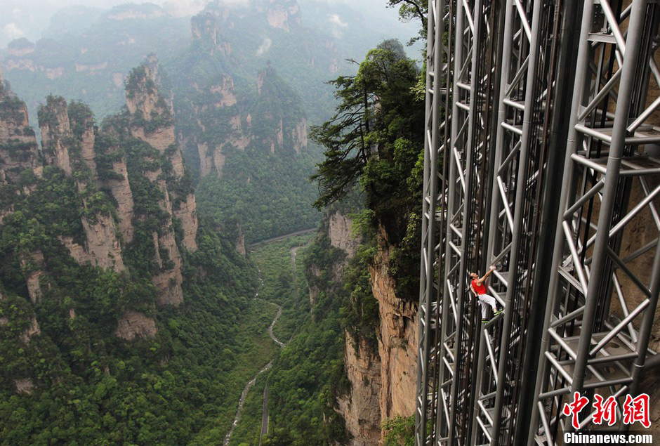 French rock climber Jean-Michel Casanova climbs the 172-meter tall metal elevator frame in Zhangjiajie, a scenic spot in Central China's Hunan province, May 18, 2013.(Photo/ Chinanews.com)