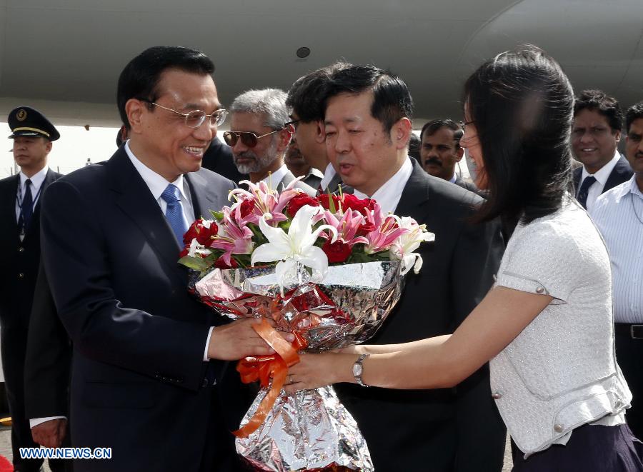 Chinese Premier Li Keqiang (L, front) receives flowers upon his arrival at an airport in New Delhi, India, kicking off an official visit to the country, on May 19, 2013. (Xinhua/Ju Peng)