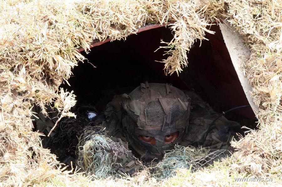 A soldier participates in a hostage rescue simulation during the 4th International Exhibition of Technology for Defense and Natural Disaster Prevention (SITDEF, by its Spanish Acronym) in the army headquarters, in San Borja district, department of Lima, Peru, on May 19, 2013. The SITDEF 2013 ran from May 15 to 19. (Xinhua/Luis Camacho) 