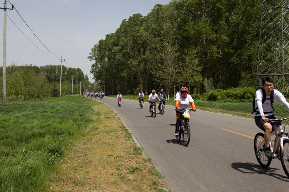 Cyclists competing in the "Climate Race" ride along a bike lane in Yanqing County on Sunday, May 19, 2013. Yanqing aims to become the "No. 1 county for bicycling in China." Wide biking lanes and a beautiful landscape near the Great Wall make the county the ideal place for biking. [Photo: CRIENGLISH.com/ Cui Chaoqun]