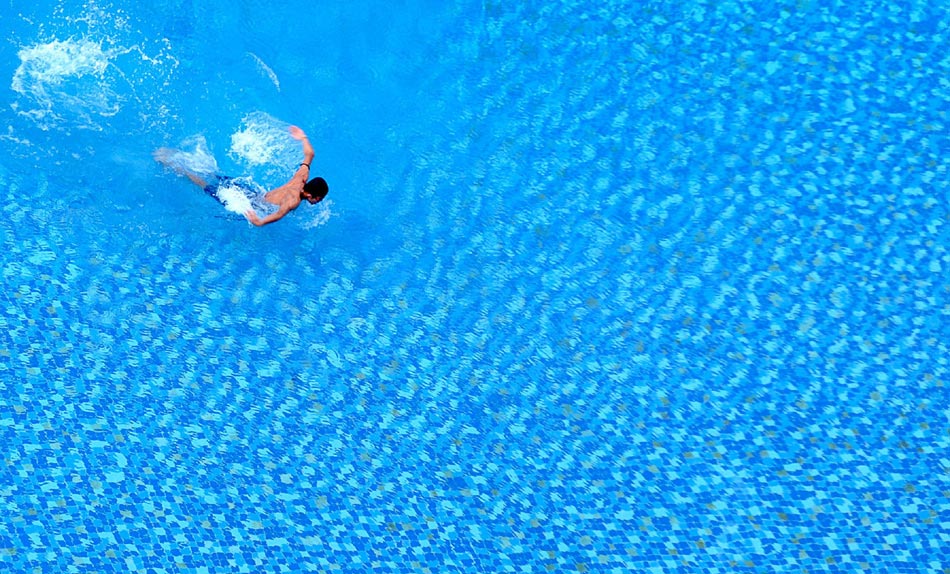 A visitor swims in a thermal spring swimming pool on May 18, 2013, at Guanlan Lake Holiday Resort in Haikou city, Hainan province.  (Photo/Xinhua)