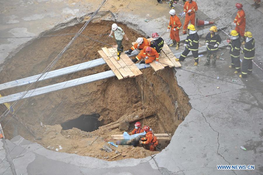Rescuers work at the accident site where a road cave-in occurred in Huamao Industrial Park in Shenzhen, south China's Guangdong Province, May 21, 2013. The accident occurred around 9:19 p.m. (1319 GMT) on May 20. As of 4:30 p.m. (0830 GMT) Tuesday, five bodies had been retrieved from a pit measuring three to four meters deep. Search and rescue efforts are under way. (Xinhua)