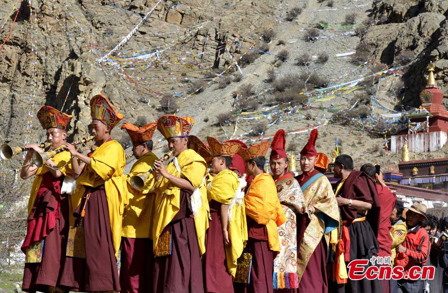 Lamas attend the Thangka Festival held at Tsurphu Monastery in Tibet Autonomous Region, May 21, 2013. The Thangka Festival is an important festival at Tsurphu Monastery, attracting many believers to the monastery to pray, get blessed and appreciate the big and vividly woven thangka. A thangka is a painting on silk with embroidery, usually depicting a Buddhist deity, scene, or mandala of some sort. Tsurphu Monastery is the most important monastery of the Karma Kagyu lineage, which is probably the largest and certainly the most widely practiced lineage within the Kagyu school, one of the four major schools of Tibetan Buddhism. [Photo: CNS/Li Lin]