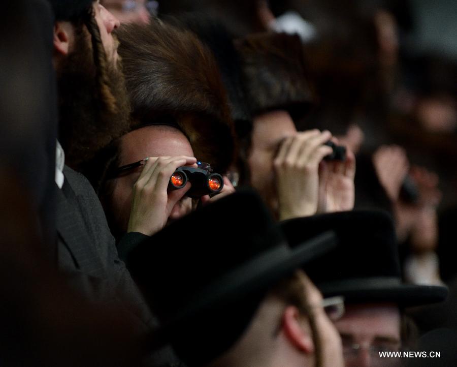Jews of the Belz Hasidic Dynasty use binoculars to watch the wedding ceremony of Rabbi Shalom Rokeach, the grandson of the Belz Rabbi Yissachar Dov Rokeach, at the neighbourhood of Kiryat Belz in Jerusalem on May 21, 2013. More than 10,000 Jews participated in the wedding. (Xinhua/Yin Dongxun) 