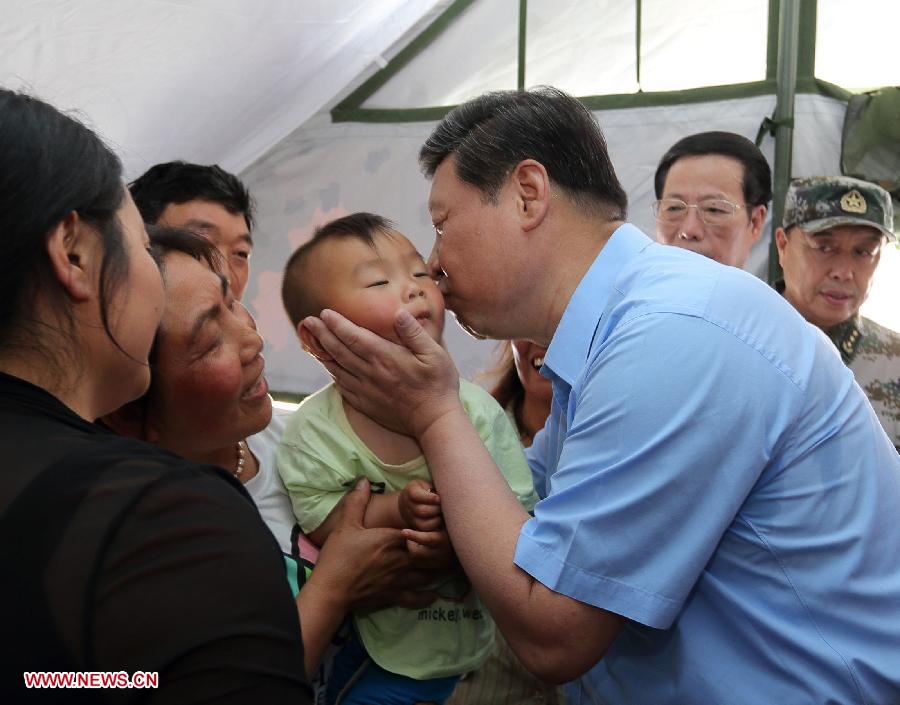 Chinese President Xi Jinping (1st R, front) kisses a child at a temporary shelter for quake-affected residents in Lushan County, southwest China's Sichuan Province, May 21, 2013. Xi made an inspection tour to hard-hit Lushan county and visited local residents from May 21 to May 23. A 7.0-magnitude earthquake hit Lushan on April 20, killing at least 196 people. (Xinhua/Lan Hongguang) 