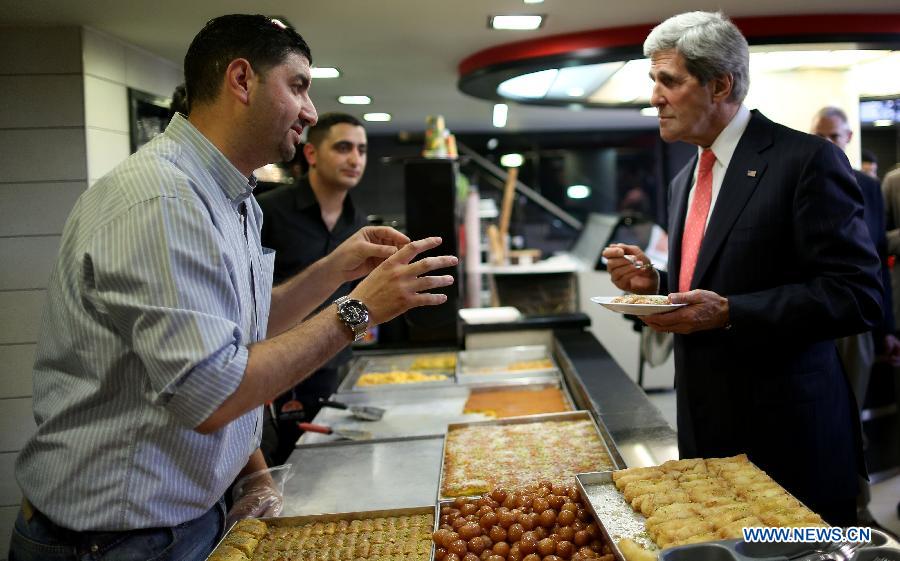 U.S. Secretary of State John Kerry (R) visits a food shop after his meeting with Palestinian President Mahmoud Abbas in the West Bank city of Ramallah on May 23, 2013. (Xinhua/Fadi Arouri-POOL) 