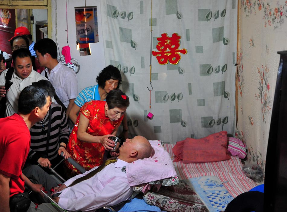Wang Mingfang helps her husband take medicine in Wuhan, Central China's Hubei province, on May 21. (Photo/ Xinhua)