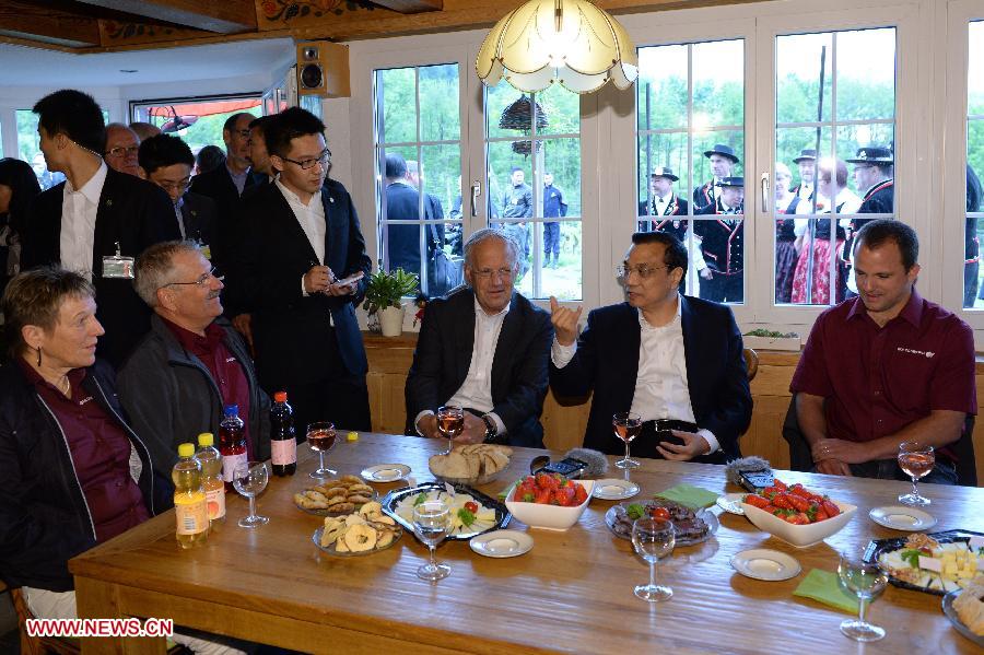 Chinese Premier Li Keqiang (2nd R) chats with the farm owner family while visiting the Guldenberg farm in Zurich, Switzerland, May 24, 2013. (Xinhua/Ma Zhancheng)