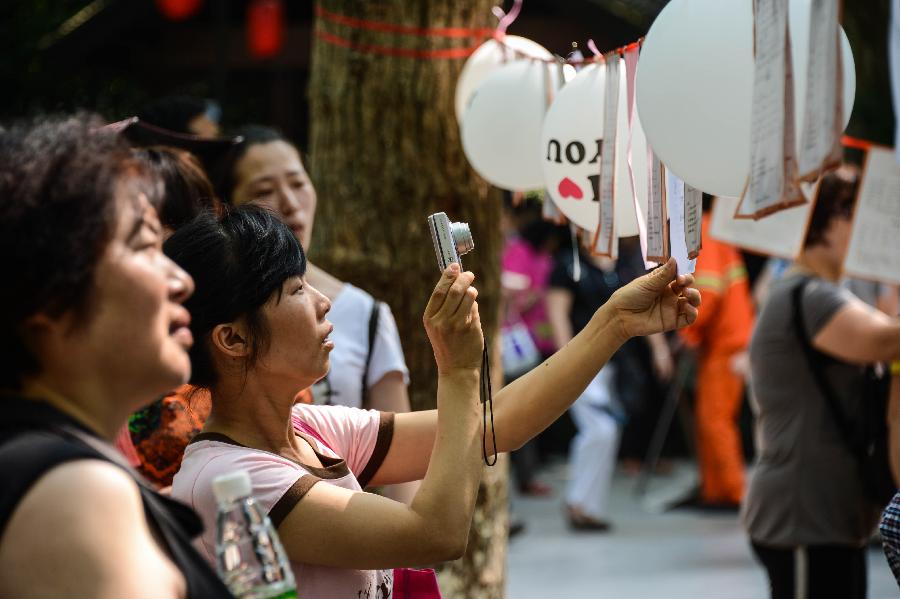 Women take part in a blind date event at Huanglongdong scenic area in Hangzhou, capital of east China's Zhejiang Province, May 25, 2013. The event attracted over 5,000 participants, including both young singles and their parents. (Xinhua/Xu Yu)