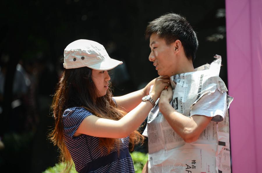 Young singles play a game during a blind date event at Huanglongdong scenic area in Hangzhou, capital of east China's Zhejiang Province, May 25, 2013. The event attracted over 5,000 participants, including both young singles and their parents. (Xinhua/Xu Yu)