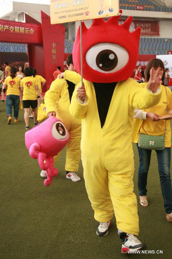 A model wearing a cartoon suit attracts buyers at the 55th house fair in Nantong, east China's Jiangsu Province, May 25, 2013. Eye-catching models highlighted the fair here. (Xinhua/Cui Genyuan) 