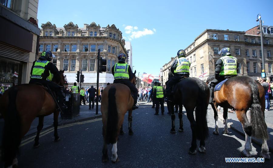 Police stand guard while protesters attend the demonstration against the killing of the British soldier in Newcastle, May 25, 2013. Nearly 2,000 people from around Britain took to the street on Saturday afternoon in Newcastle in northern England. (Xinhua/Yin Gang) 