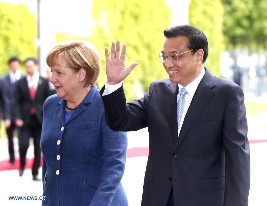 Chinese Premier Li Keqiang (R) attends a welcoming ceremony held by German Chancellor Angela Merkel (L) in Berlin, capital of Germany, May 26, 2013. (Xinhua/Ju Peng)