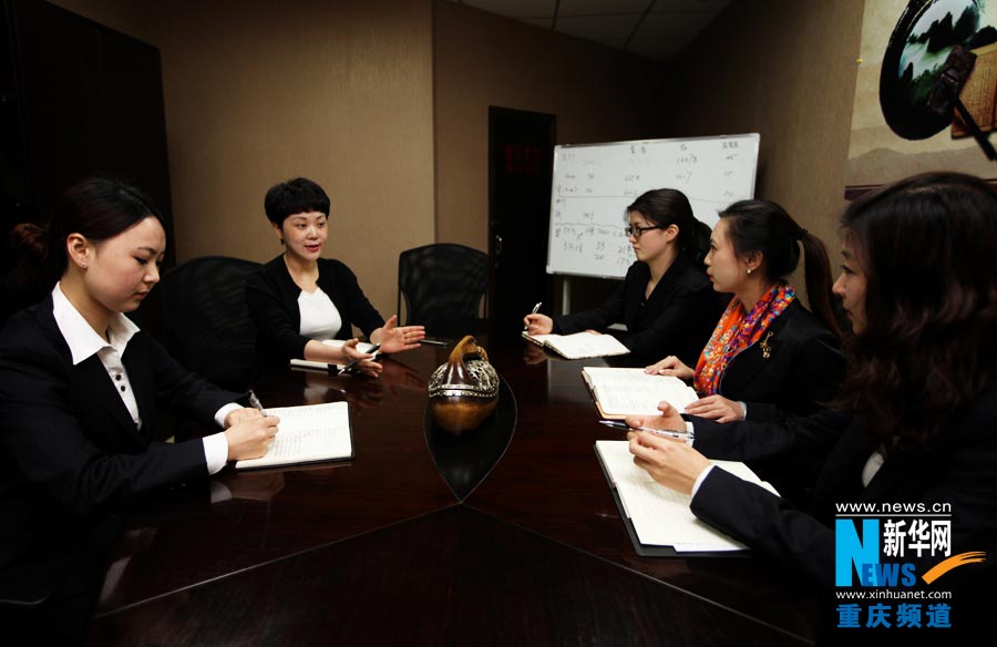 He Jinzhu explains financial knowledge to staff members in China CITIC bank’s Qingsi branch office. (Photo/Xinhua)