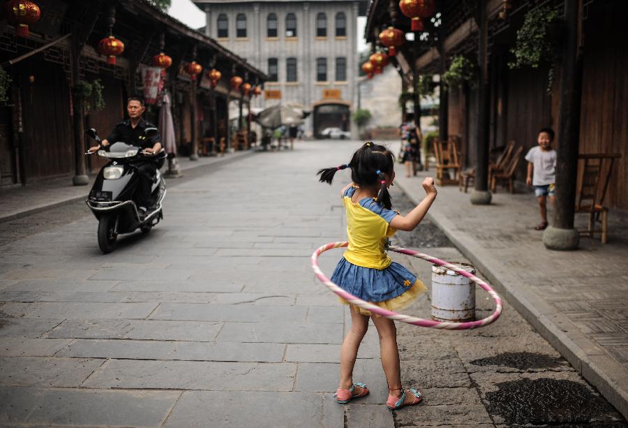 A girl plays in Anren, an ancient town in Dayi County of Chengdu, capital of southwest China's Sichuan Province, May 23, 2013. Anren Town was first built in ancient China's Tang Dynasty (618-907). Most of its buildings were constructed in late Qing Dynasty (1644-1911) and early Republic of China (1911-1949). Chengdu will host the Global Fortune Forum, an event to be organized by the American magazine "Fortune", on June 6-8. (Xinhua/Shen Hong)  