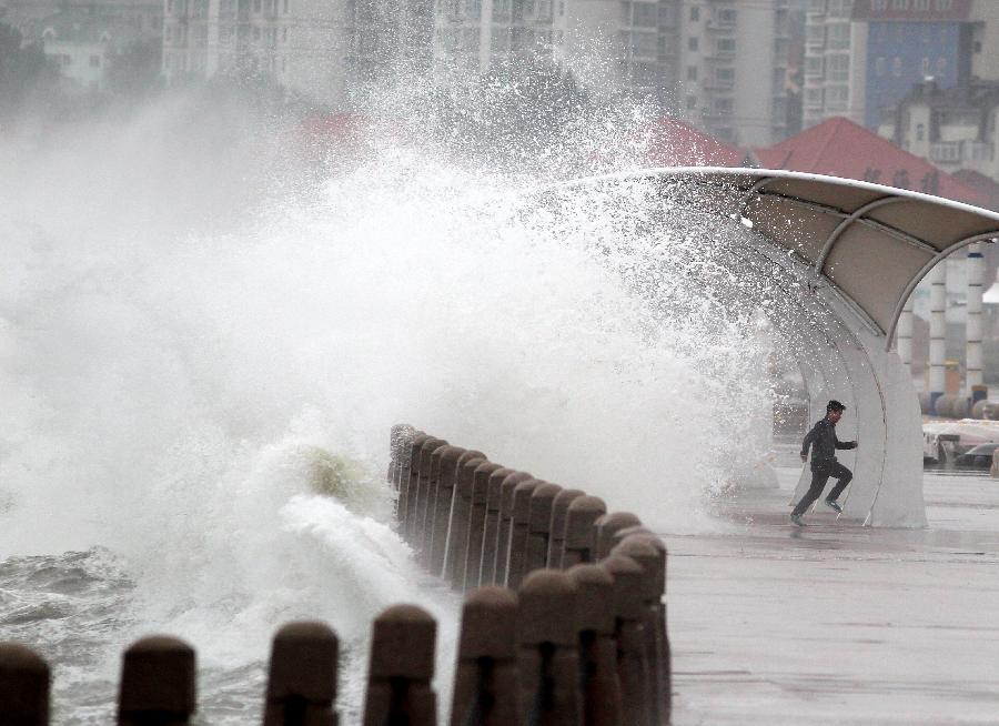 A man runs away from the wave in Yantai City, east China's Shandong Province, May 27, 2013. Shandong will witness frequent thunderstorms and downpours from Monday to Tuesday, according to the local meteorological authority. (Xinhua/Shi Liguo)