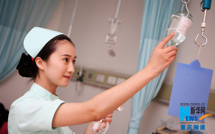 Tan Ling, a nurse in Chongqing South West Hospital, checks a patient's infusion bottle. (Xinhua/Peng Bo)