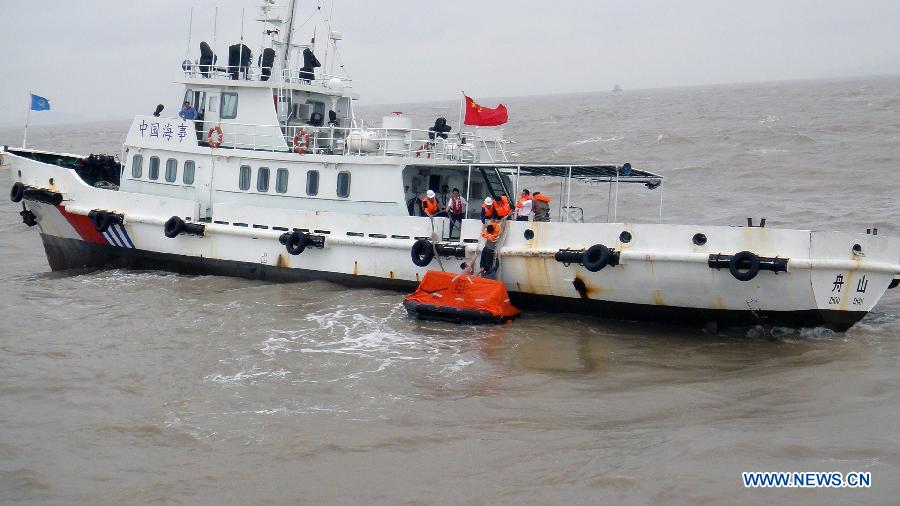 Workers of the Zhoushan Maritime Safety Administration rescue the sailors on an overturned cargo ship in Zhoushan, east China's Zhejiang Province, May 28, 2013. Altogether 9 people on the ship were rescued and one was missing after the three-hour rescue. (Xinhua/Shen Lei)