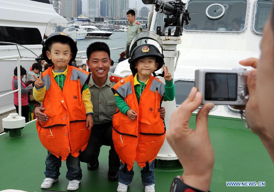 Children visit a patrol boat during an open day of local frontier defense vessel division in Qingdao, a coastal city in east China's Shandong Province, May 28, 2013. (Xinhua/Li Ziheng)